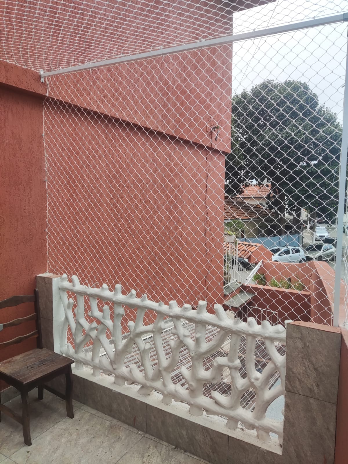Rede de proteção branca instalada em fachada de casa